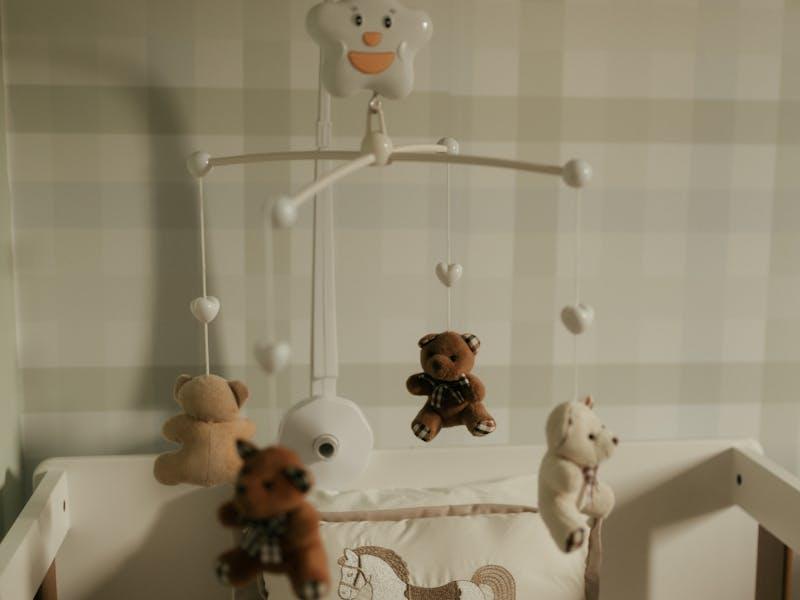 Cozy baby nursery with crib and soft teddy bear mobile